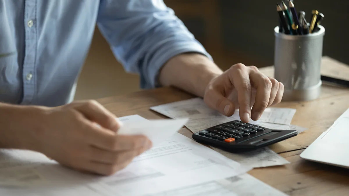 Receipts and a calculator on a desk, working out whether the tax break is worth the paperwork